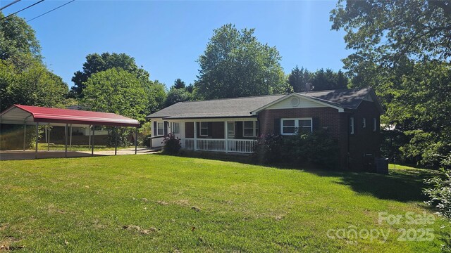 view of front of property featuring a detached carport, a porch, a front lawn, and brick siding