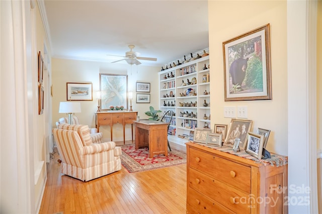 office area featuring light wood-style floors, a ceiling fan, and crown molding