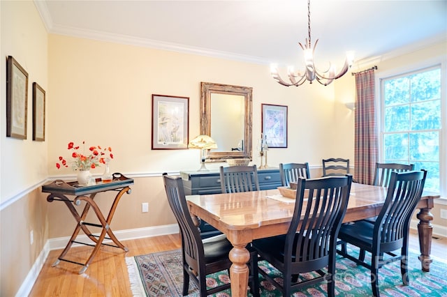 dining space featuring light wood-style floors, a chandelier, ornamental molding, plenty of natural light, and baseboards