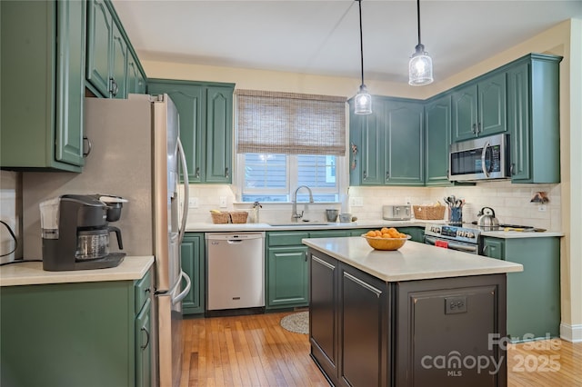 kitchen featuring appliances with stainless steel finishes, green cabinets, and a sink