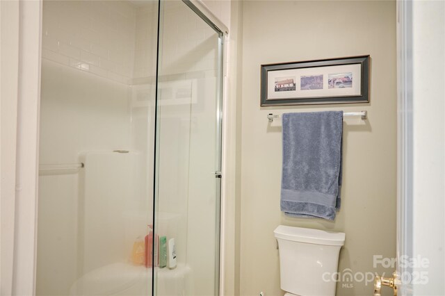 full bathroom with a shower stall and toilet