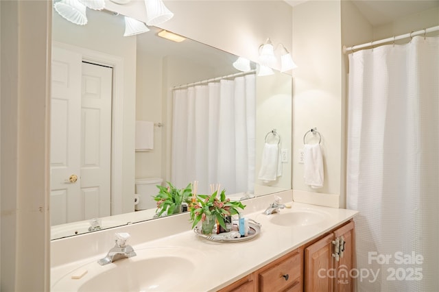 full bath featuring double vanity and toilet