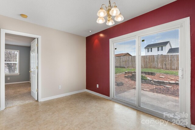 unfurnished dining area featuring a chandelier and baseboards