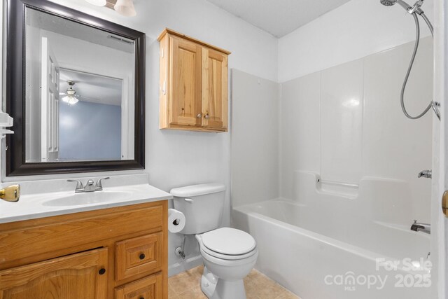 bathroom featuring toilet, vanity, tile patterned floors, baseboards, and shower / bathtub combination