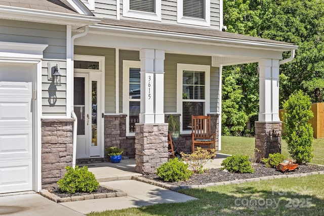 3615 Alamito Ln, Charlotte, NC 28214 - property entrance featuring covered porch, stone siding, an attached garage, and a shingled roof