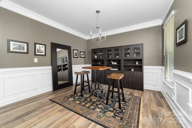 3615 Alamito Ln, Charlotte, NC 28214 - dining space featuring a chandelier, crown molding, wood finished floors, a wainscoted wall, and a decorative wall