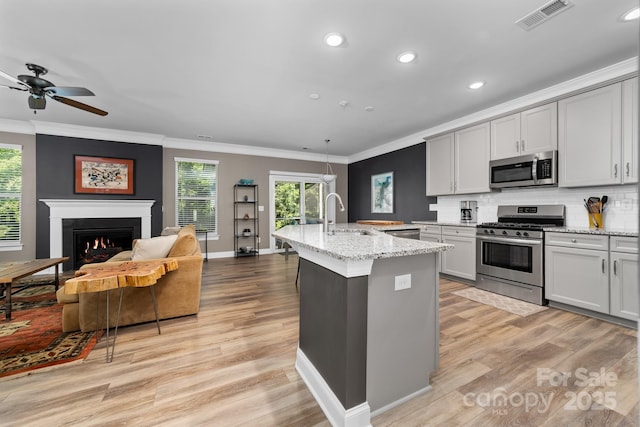 3615 Alamito Ln, Charlotte, NC 28214 - kitchen featuring appliances with stainless steel finishes, a sink, recessed lighting, crown molding, and light wood finished floors