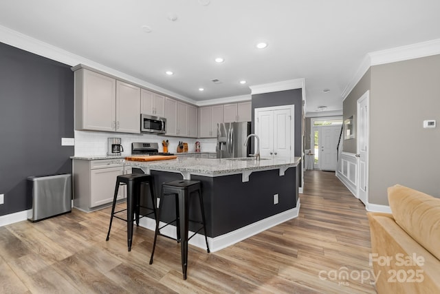 3615 Alamito Ln, Charlotte, NC 28214 - kitchen featuring appliances with stainless steel finishes, crown molding, a sink, recessed lighting, and a breakfast bar area