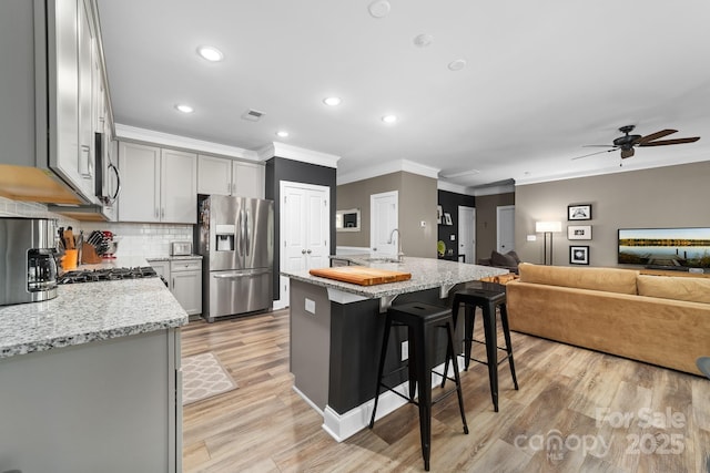 3615 Alamito Ln, Charlotte, NC 28214 - kitchen with stainless steel appliances, crown molding, a ceiling fan, a sink, and light stone counters