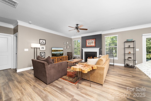 3615 Alamito Ln, Charlotte, NC 28214 - living room with wood finished floors, a ceiling fan, crown molding, a lit fireplace, and baseboards
