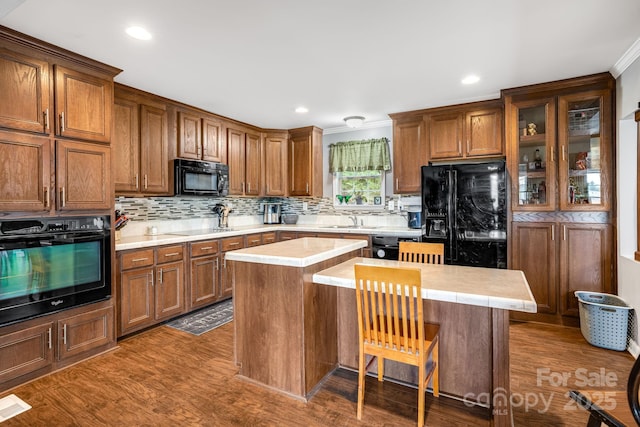 14 Phoenix Cir, Alexander, NC 28701 - kitchen with black appliances, a center island, brown cabinetry, tasteful backsplash, and crown molding