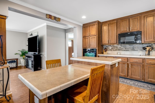 14 Phoenix Cir, Alexander, NC 28701 - kitchen with black appliances, light wood-style floors, a kitchen island, recessed lighting, and backsplash