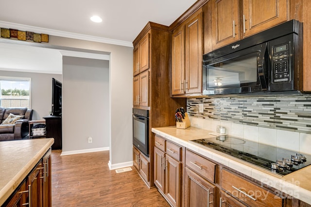 14 Phoenix Cir, Alexander, NC 28701 - kitchen featuring black appliances, baseboards, tasteful backsplash, light wood-type flooring, and brown cabinetry