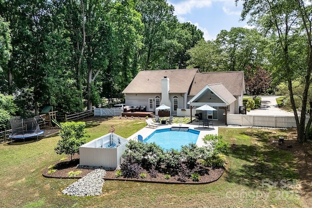 view of pool featuring a deck, a trampoline, and a patio
