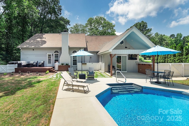 rear view of property featuring a patio area, an outdoor living space, a chimney, a gate, and ceiling fan