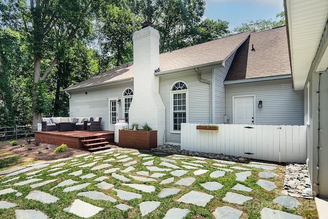 back of property featuring fence, an outdoor living space, a deck, a chimney, and a shingled roof