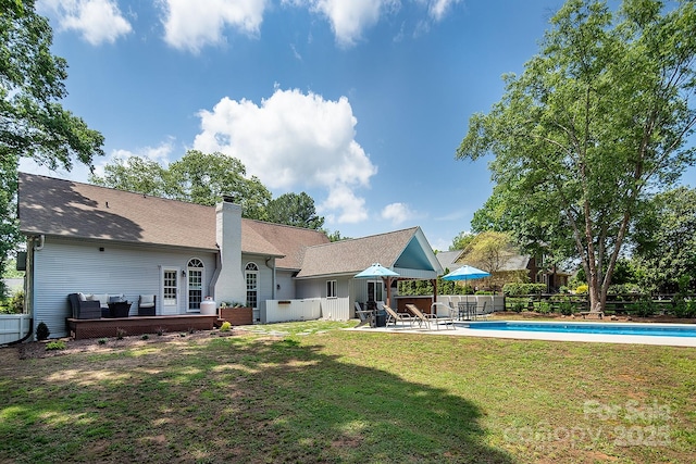 back of house featuring a chimney, a patio area, and a shingled roof