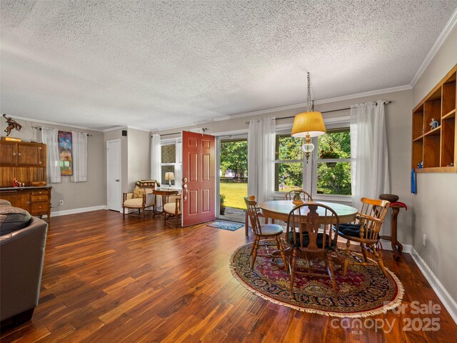 dining room with a textured ceiling, ornamental molding, dark wood-style flooring, and baseboards
