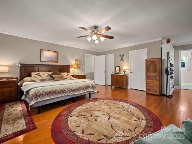 bedroom with wood finished floors, crown molding, and ceiling fan