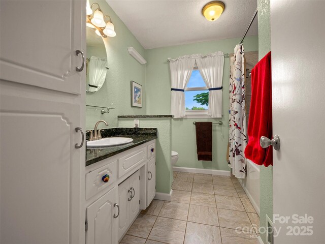 full bath featuring toilet, vanity, tile patterned floors, baseboards, and shower / tub combo