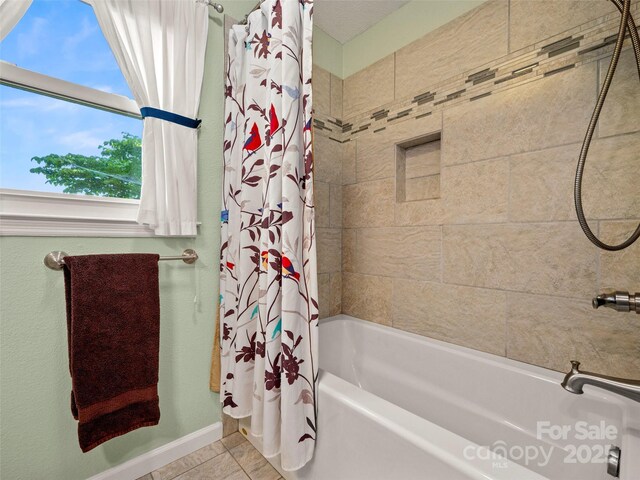full bathroom featuring shower / bath combo, tile patterned floors, and baseboards