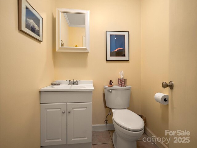 half bath with vanity, toilet, baseboards, and tile patterned flooring