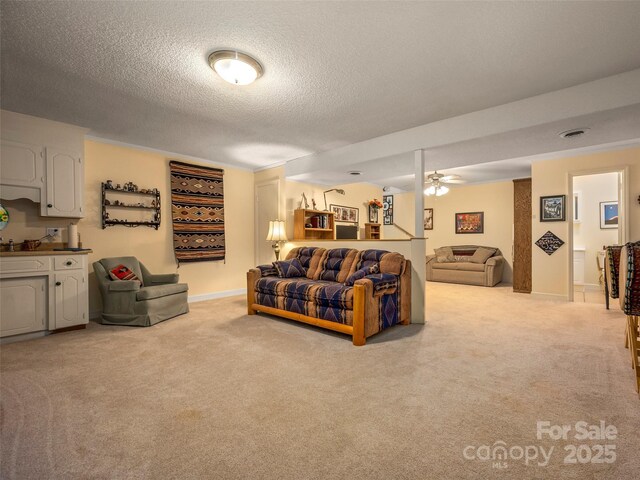 living room with light colored carpet, a textured ceiling, and ceiling fan