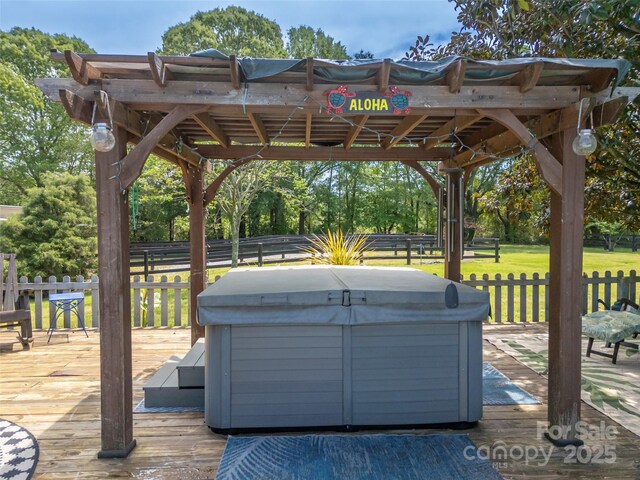 wooden deck featuring a hot tub and view of scattered trees
