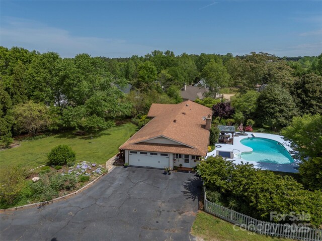 bird's eye view of a heavily wooded area and a pool area