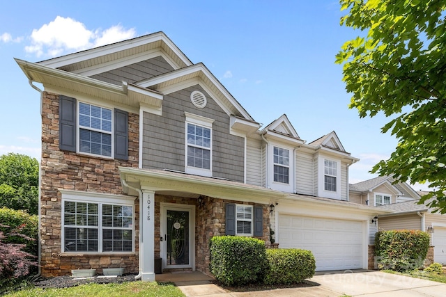 view of front of home featuring stone siding, concrete driveway, and an attached garage
