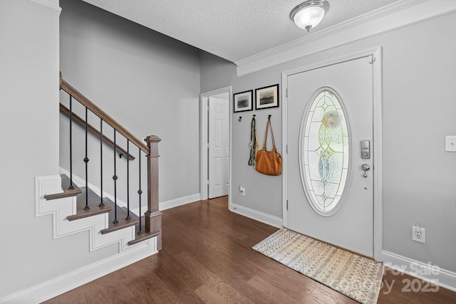 entrance foyer featuring a textured ceiling, wood finished floors, stairway, baseboards, and ornamental molding