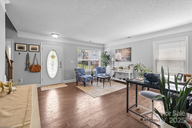 entrance foyer with a textured ceiling, ornamental molding, and dark wood-style flooring