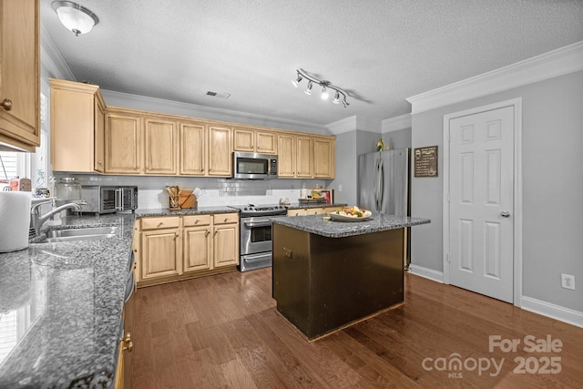 kitchen featuring stainless steel appliances, a sink, a textured ceiling, a kitchen island, and dark wood-type flooring