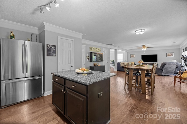 kitchen with freestanding refrigerator, ceiling fan, a textured ceiling, dark wood-type flooring, and open floor plan