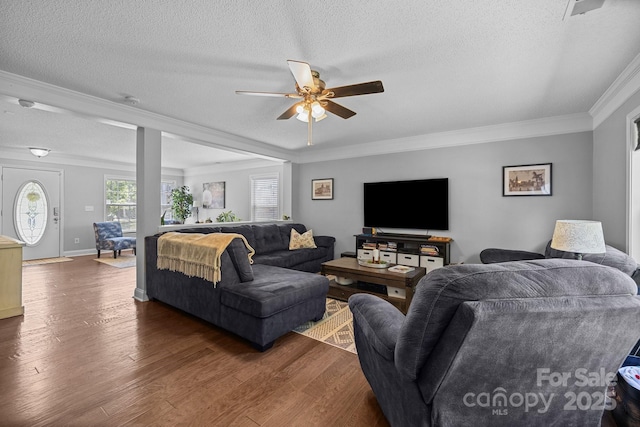 living area with ceiling fan, dark wood-type flooring, ornamental molding, a textured ceiling, and baseboards