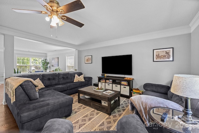 living room featuring ornamental molding, wood finished floors, and a ceiling fan