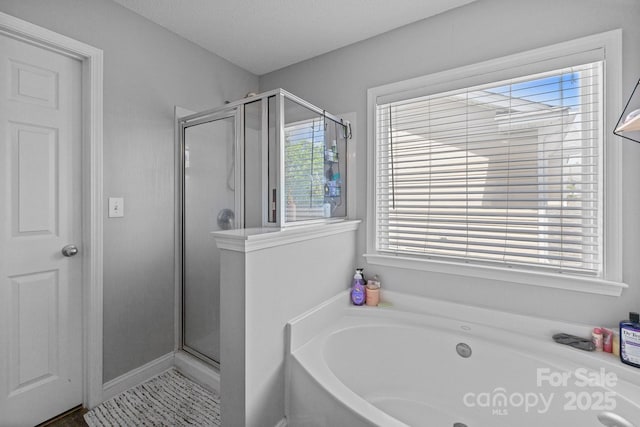 bathroom featuring a stall shower and a bath
