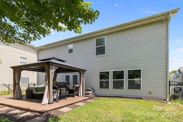 rear view of house featuring a gazebo, a wooden deck, and a yard