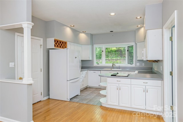 kitchen with white appliances, a sink, light wood-style floors, white cabinetry, and open shelves