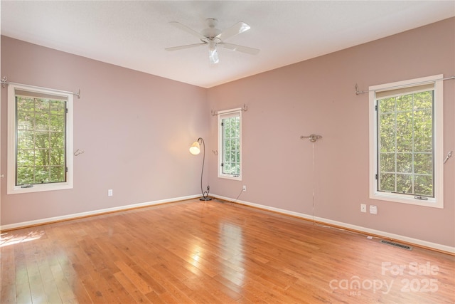spare room with light wood-style floors, baseboards, and a ceiling fan