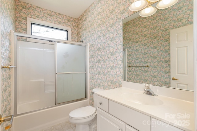 full bathroom featuring wallpapered walls, toilet, vanity, tile patterned flooring, and combined bath / shower with glass door