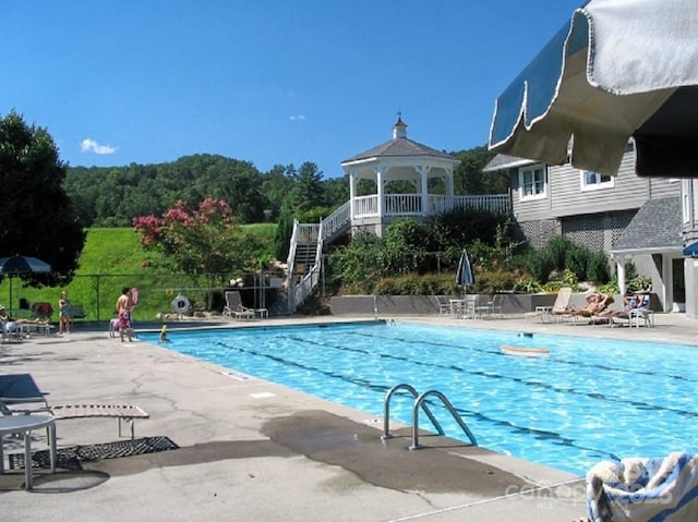 community pool featuring a gazebo, fence, and a patio area