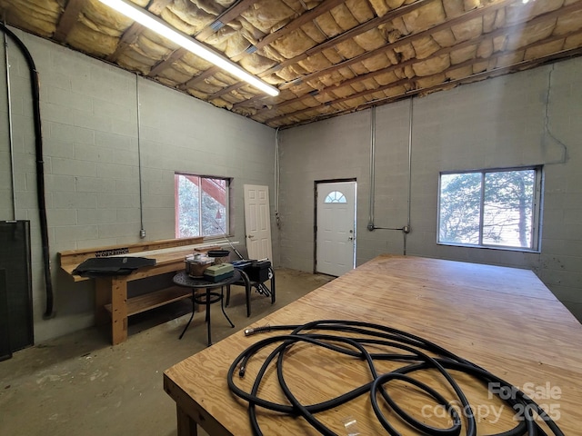 foyer entrance featuring unfinished concrete flooring and concrete block wall