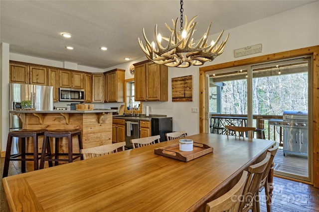 dining room featuring a chandelier, healthy amount of natural light, recessed lighting, and wood finished floors