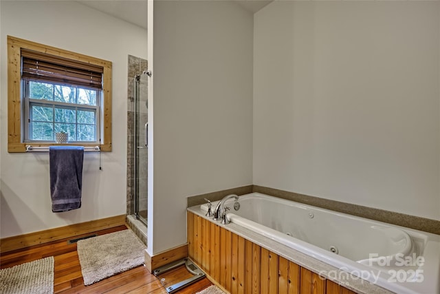full bath with a shower stall and a jetted tub