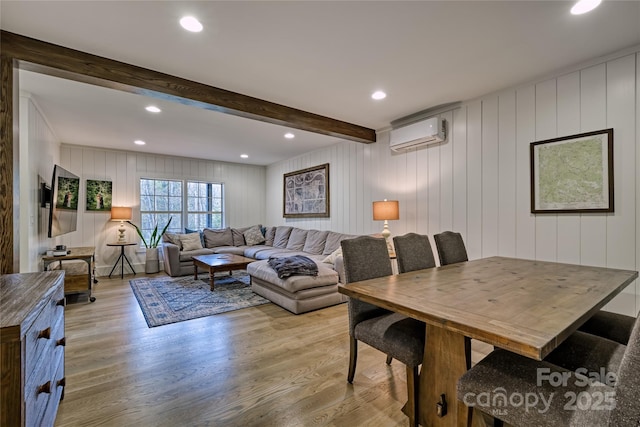 dining space featuring a wall unit AC, light wood-type flooring, beam ceiling, and recessed lighting
