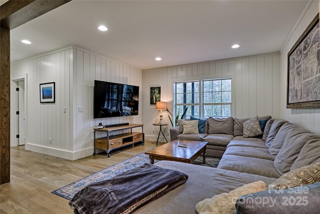 living area featuring wood finished floors, baseboards, recessed lighting, and crown molding