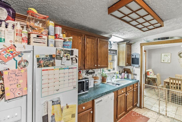 4155 Slanting Bridge Rd, Sherrills Ford, NC 28673 - kitchen with white appliances, a sink, a textured ceiling, light tile patterned floors, and brown cabinets