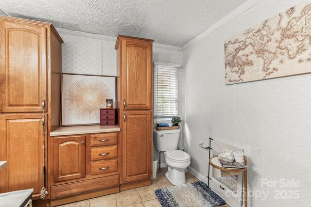 4155 Slanting Bridge Rd, Sherrills Ford, NC 28673 - bathroom with crown molding, toilet, tile patterned floors, a textured ceiling, and wallpapered walls