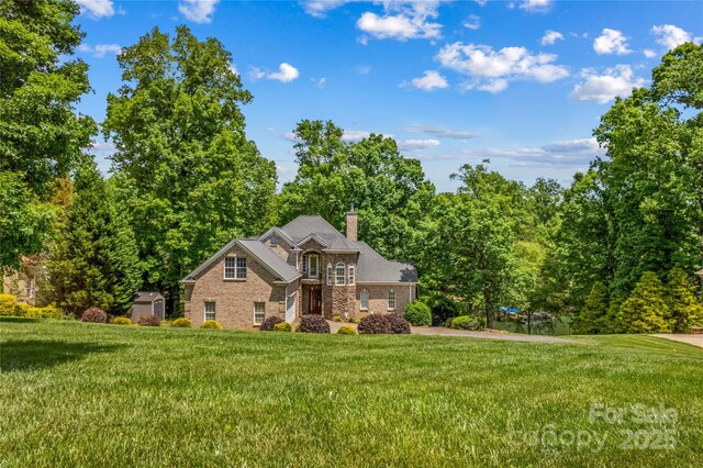 141 Ridge Top Rd, Mooresville, NC 28117 - view of front of house with a front lawn, a chimney, stone siding, and brick siding